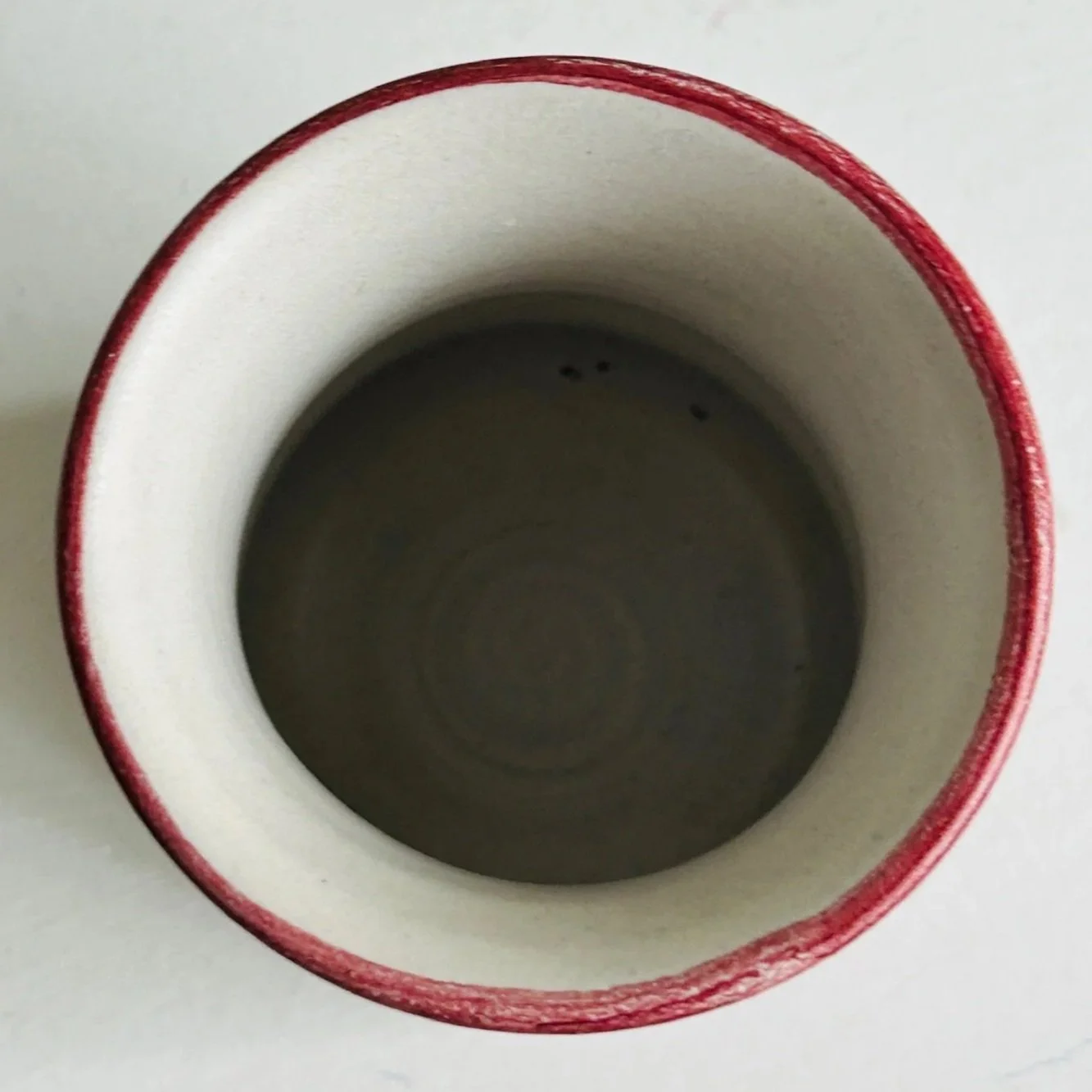 Top-down view into the vase showing the interior and burgundy-painted rim