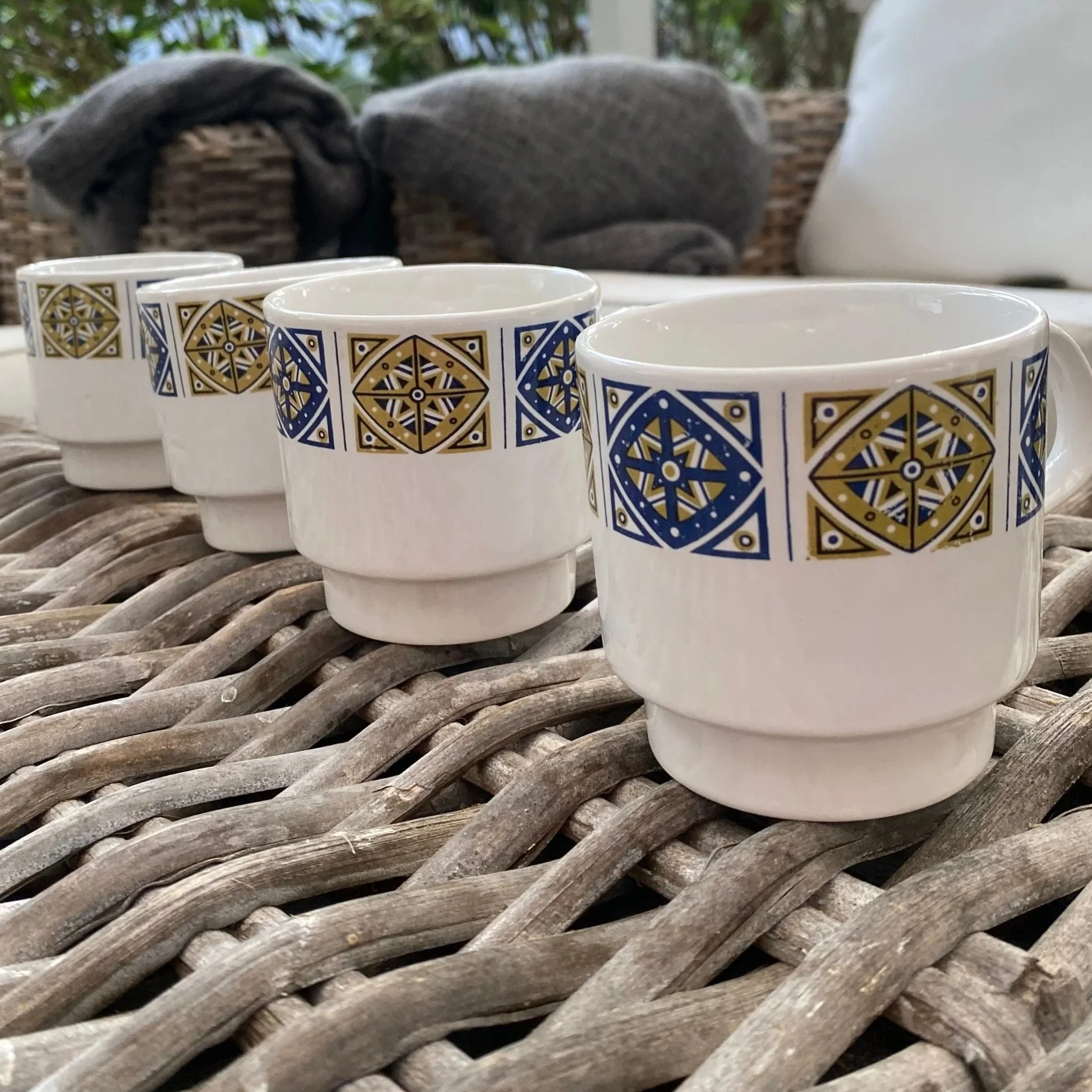 Side view of four Staffordshire Midas mugs lined up, showing bold geometric pattern