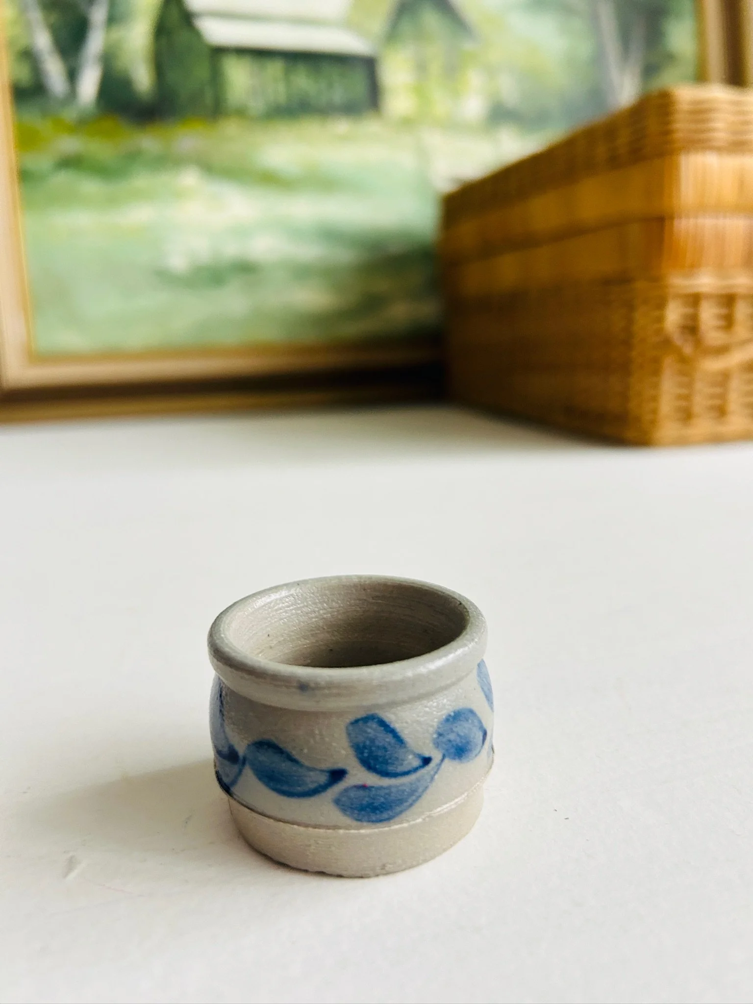 Three-quarter front view of the small blue leaf salt cellar on a white surface, showing its compact scale and rustic finish