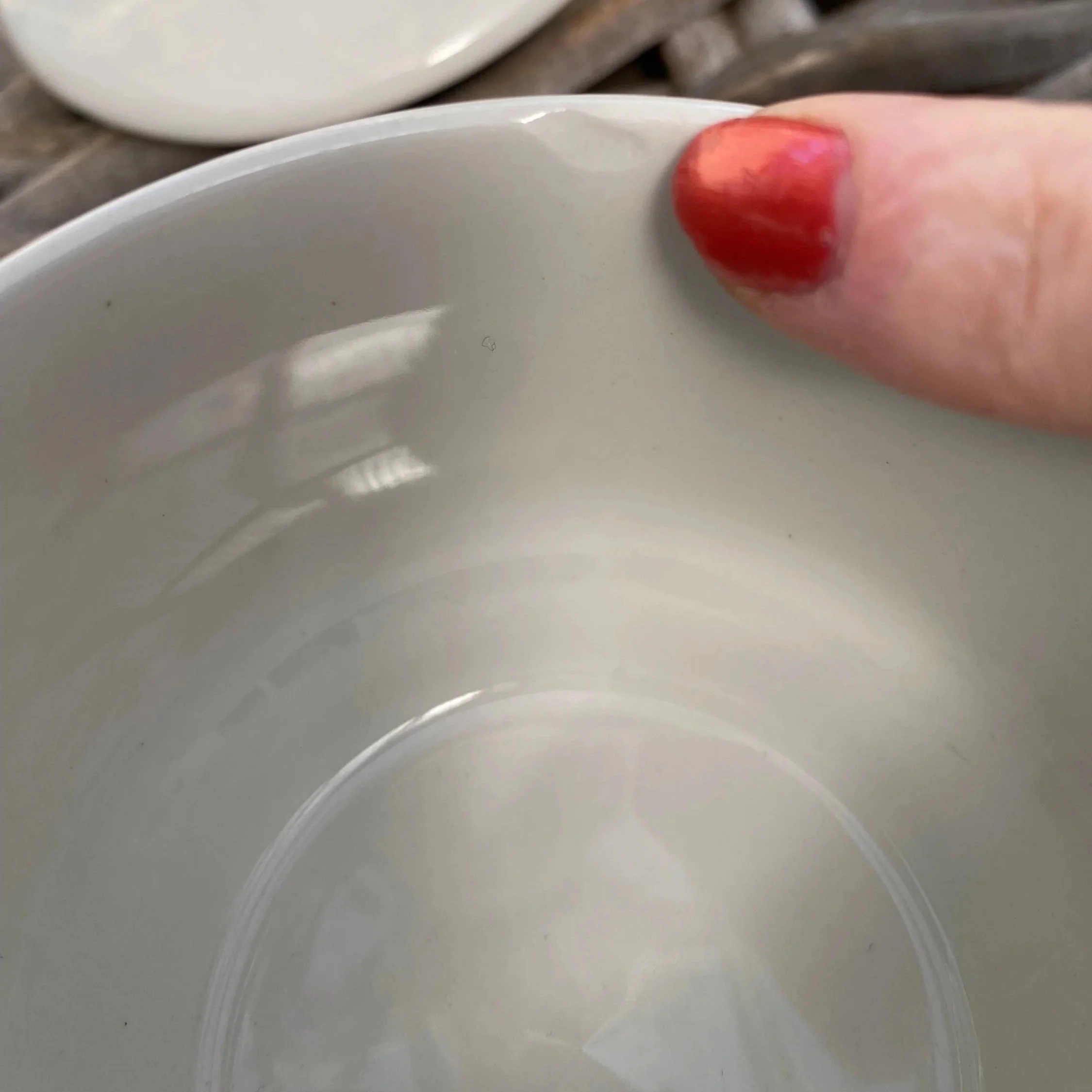 Close-up of chip inside the rim pointed out with red nail for scale