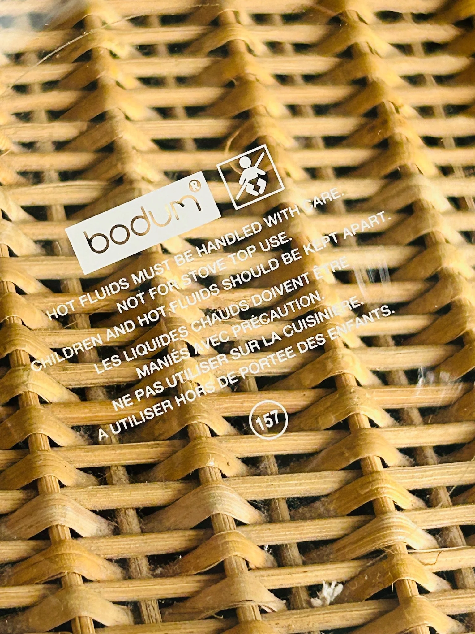 Close-up of the Bodum logo and safety markings printed on the glass teapot body.