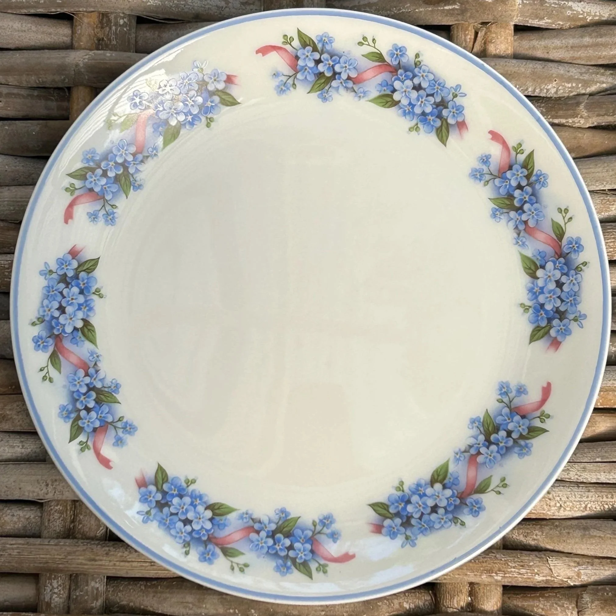 Single plate showing full floral border of blue flowers and pink ribbons