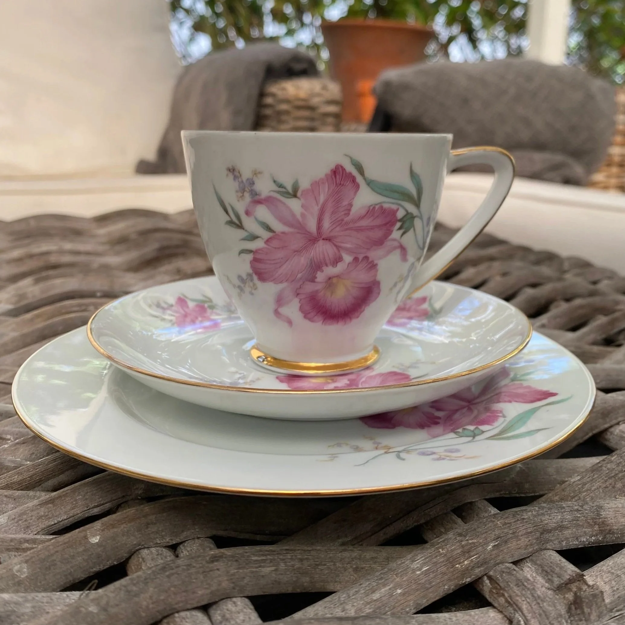 Close-up of the second teacup trio with soft pink floral motif and gold trim detail