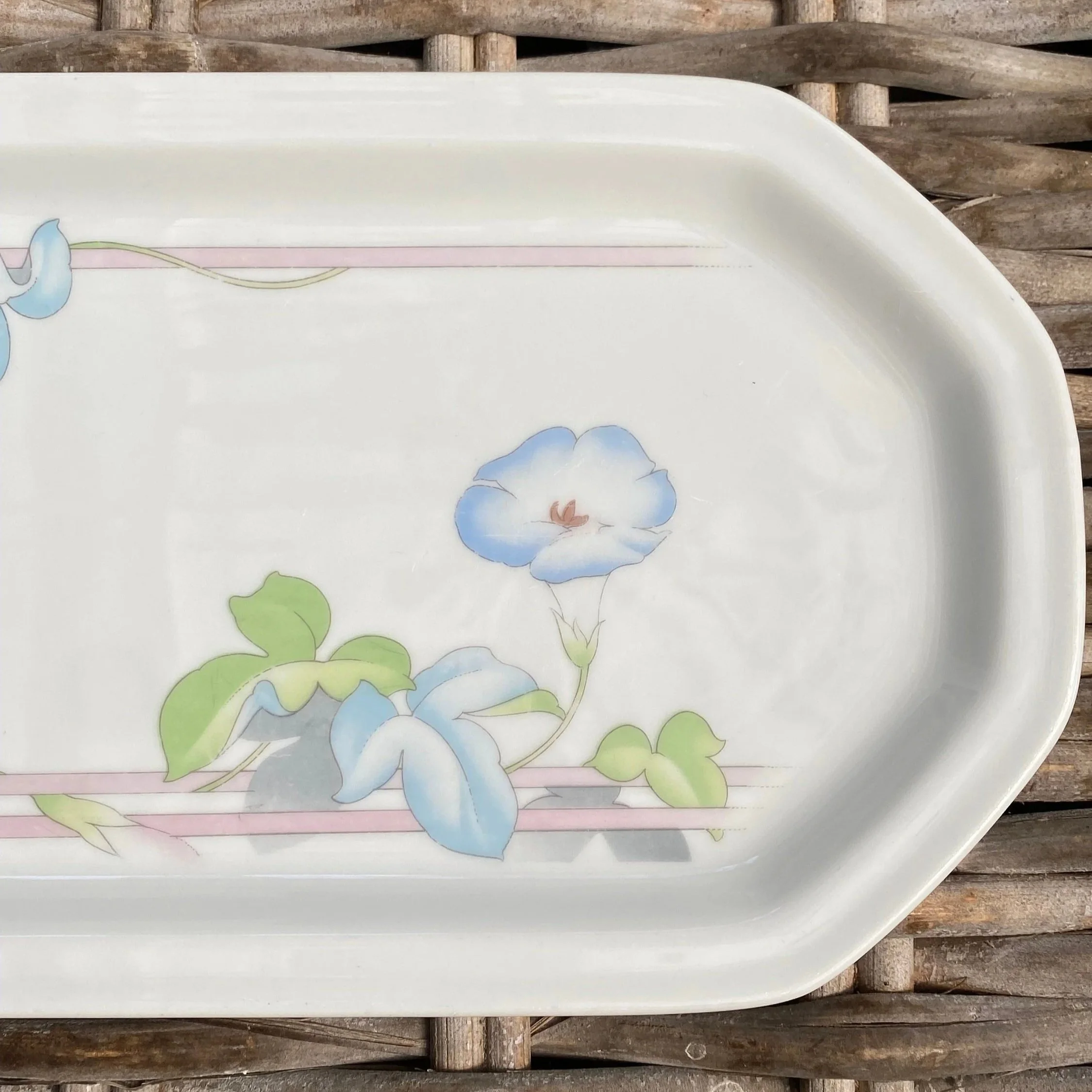 Close-up of one end of the platter showing the soft blue flower and pink line border detail