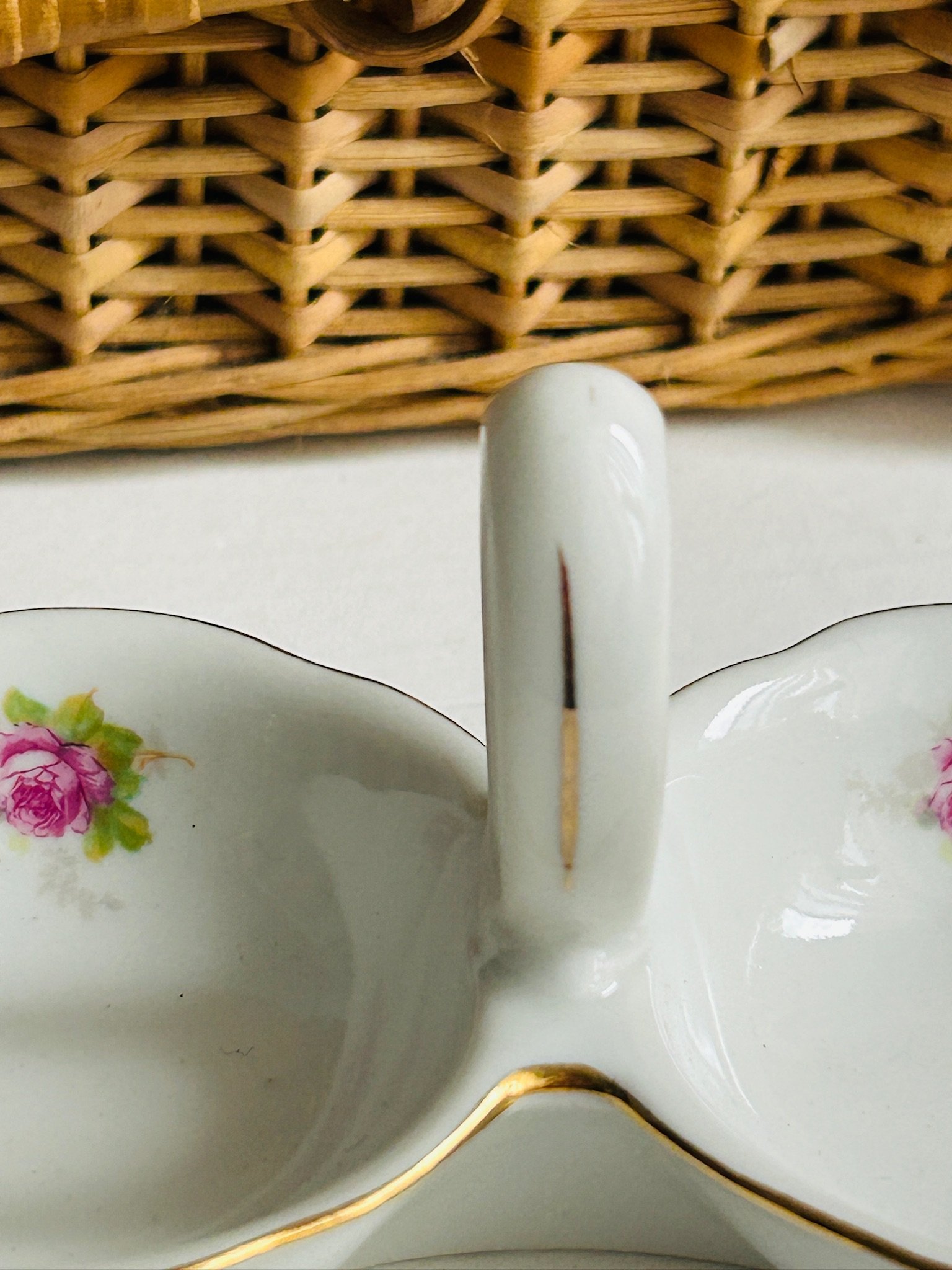 Close-up of the loop handle and interior floral details on both bowls