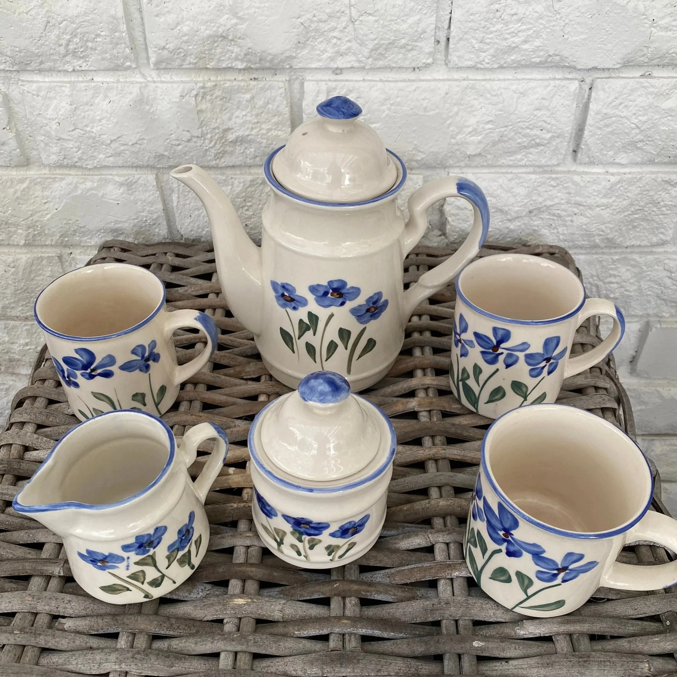 Full 6-piece coffee set including coffee pot, 4 mugs, sugar pot, and milk jug on wicker surface