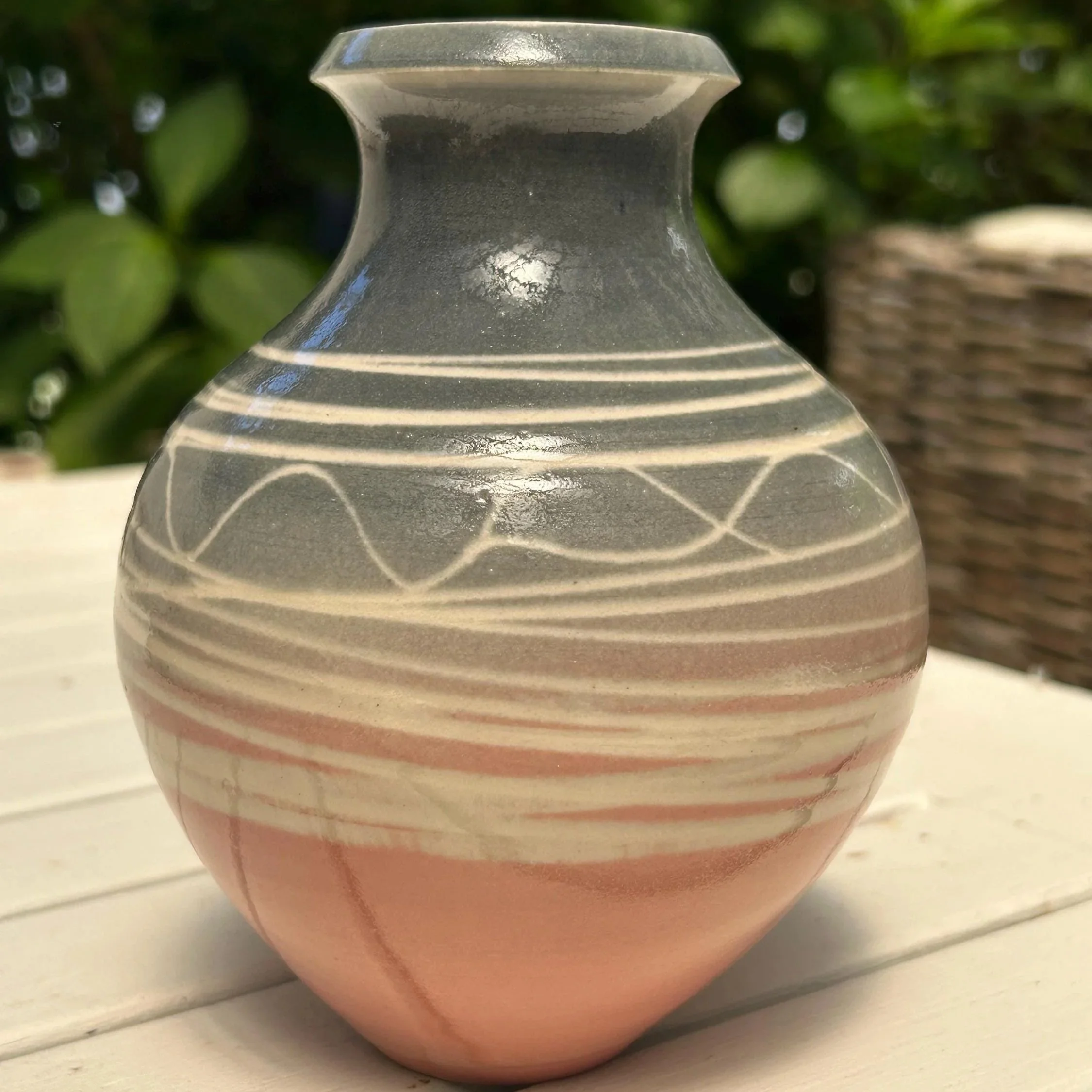 Full view of handmade studio pottery vase with grey top and pink base