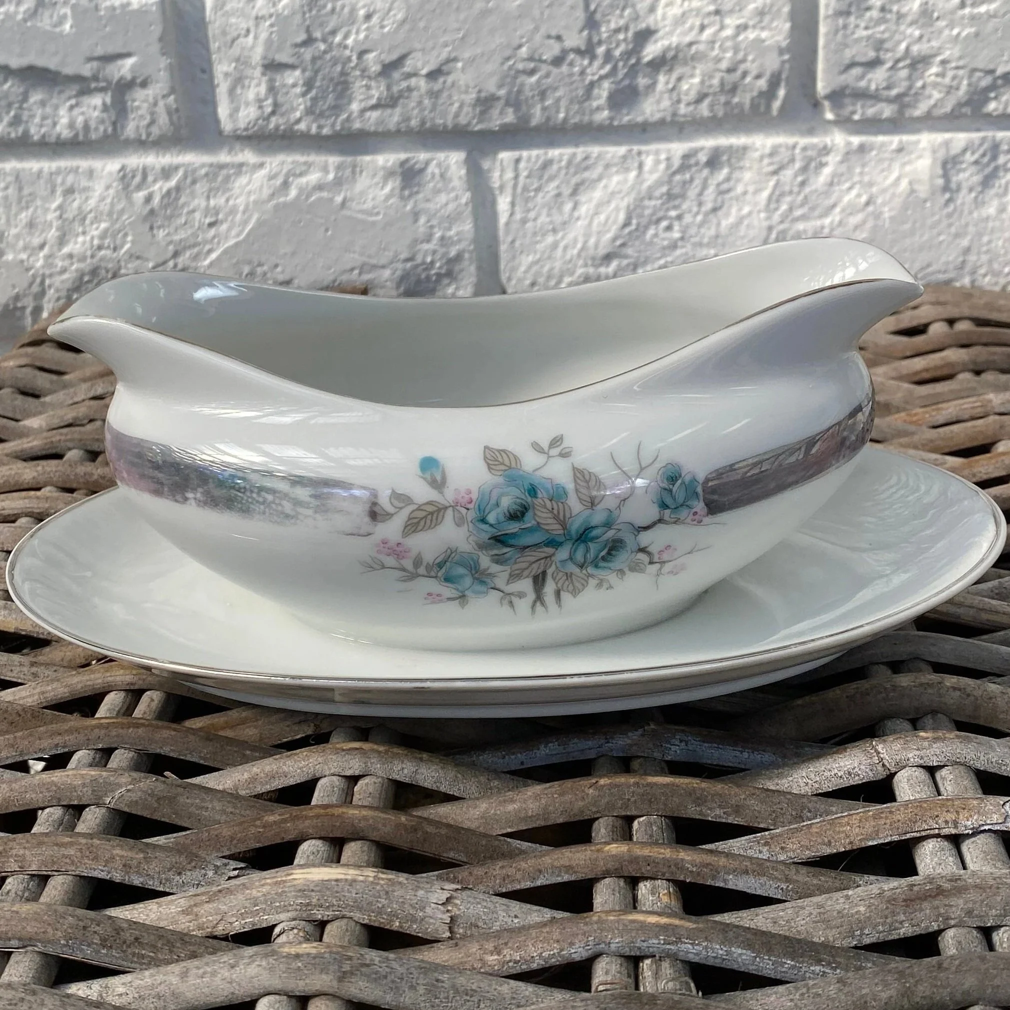 Matching porcelain gravy boat with floral motif and teal accent band
