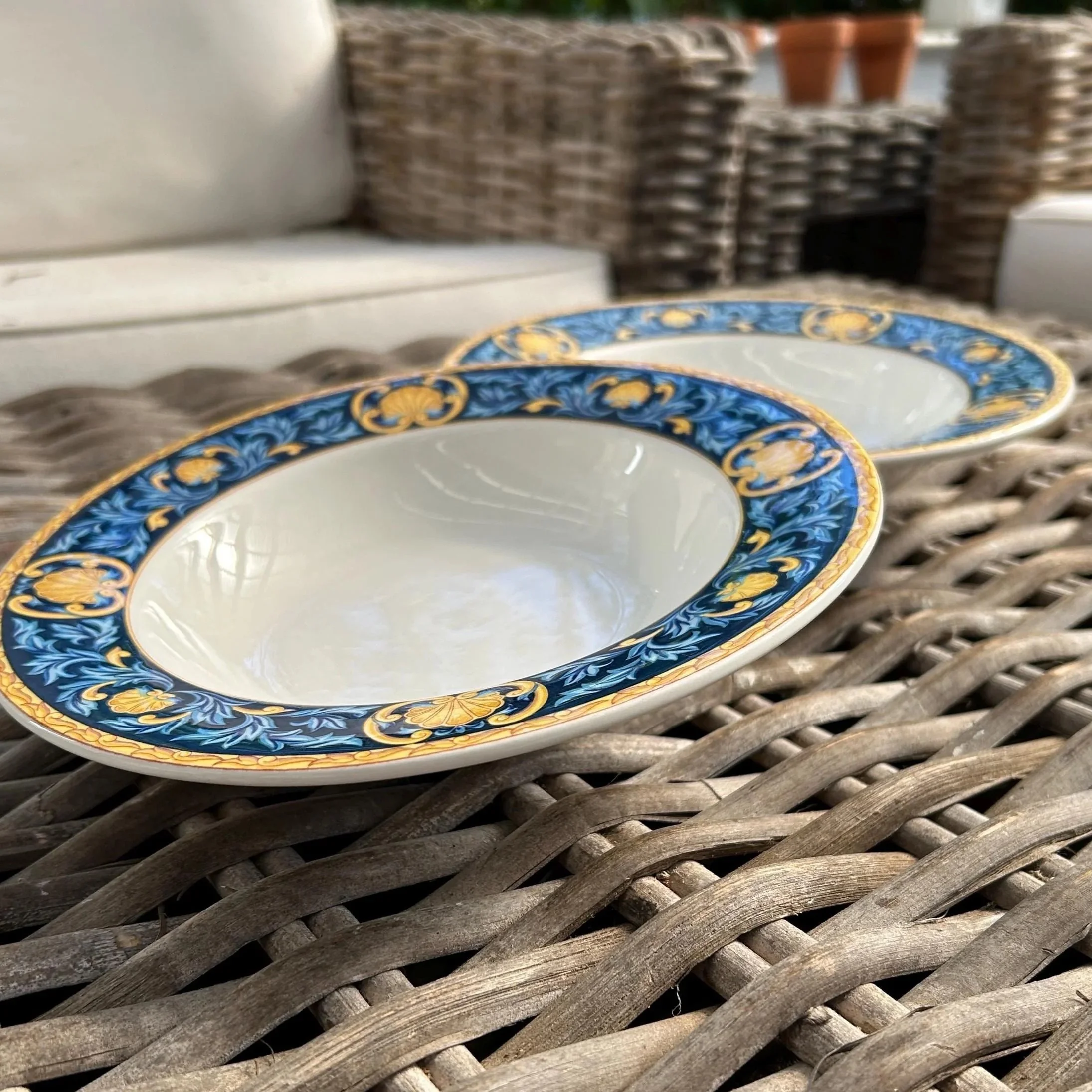 Side view of both bowls stacked, showing gold and blue rim pattern