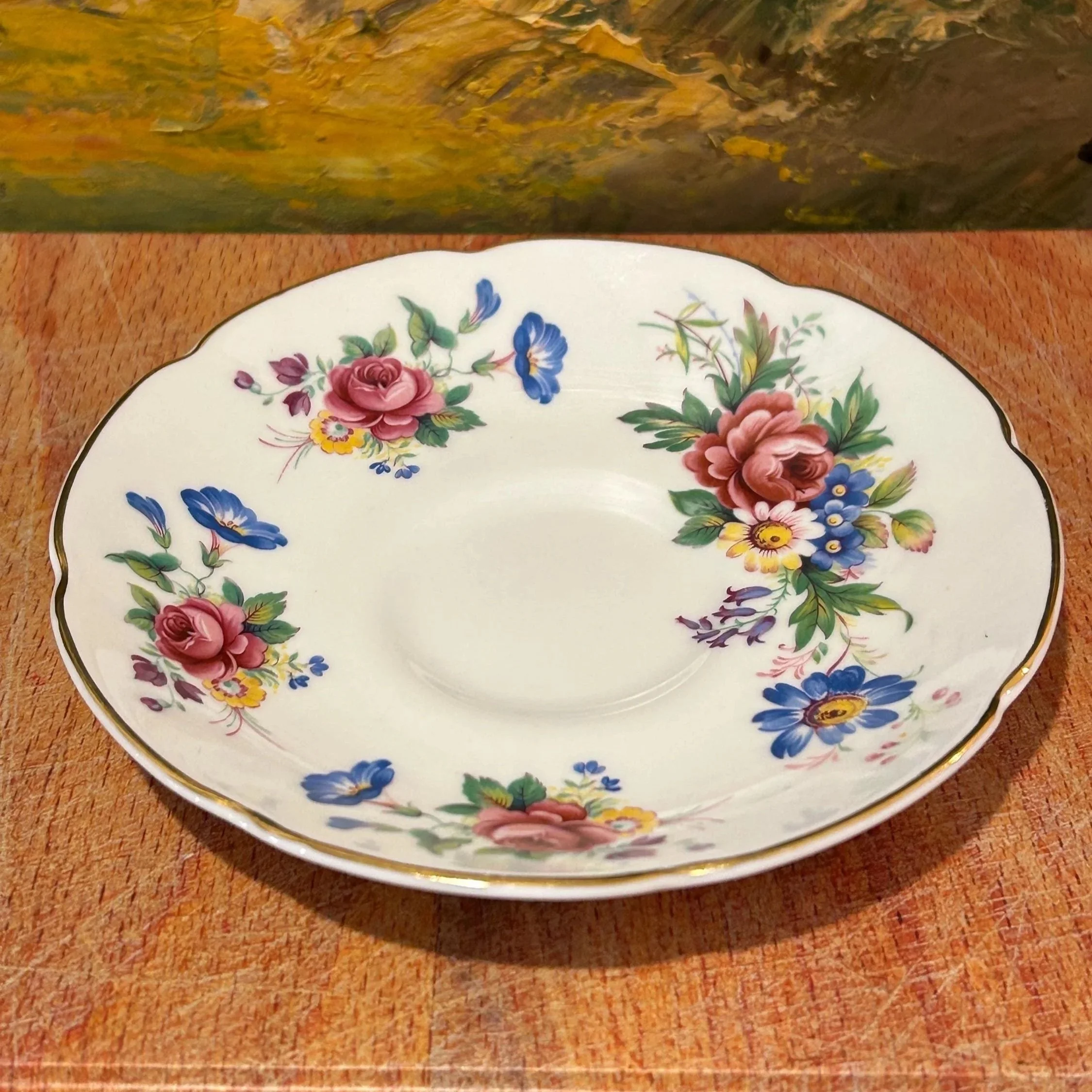 Saucer close-up featuring floral clusters and scalloped edge