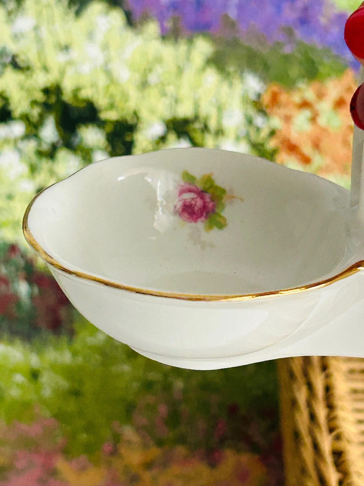 Side close-up of one bowl showing the pink rose decal and gold rim