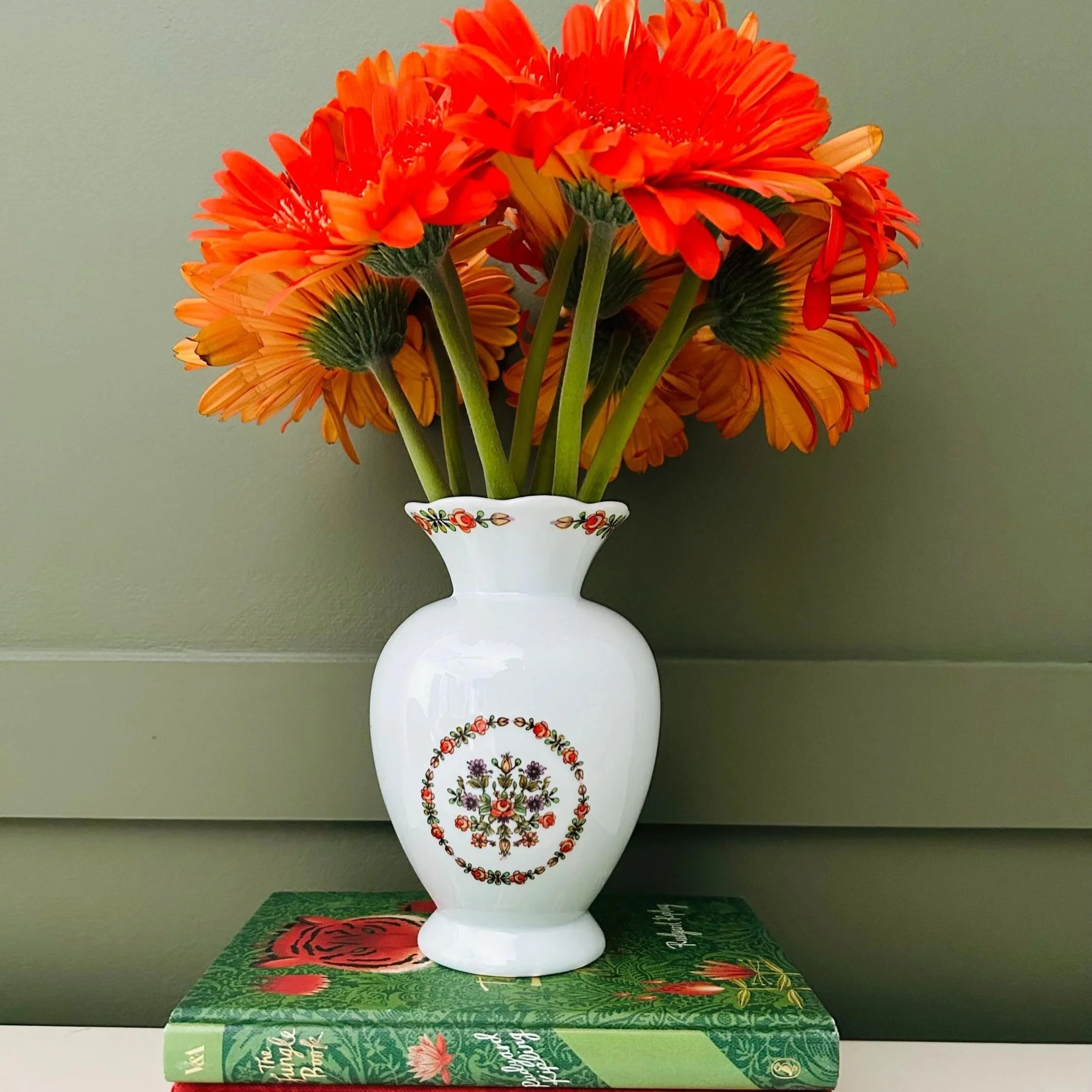 Porcelana Schmidt vase with bright orange flowers styled in a retro setting