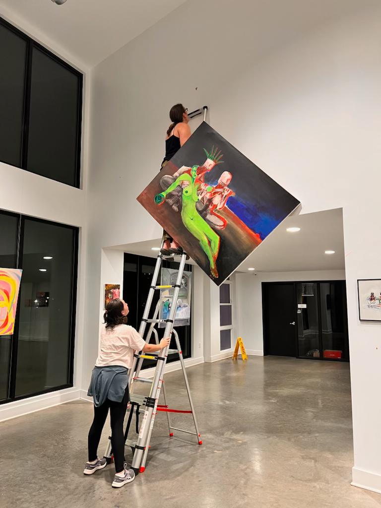 The artist installing "Fanaticism and Ignorance," for Seen, March 2025. 