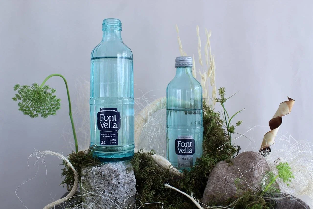 Font Vella water bottles integrated into a contemporary floral installation with moss, rocks and natural materials, created by floral artist Ceci Bordas.