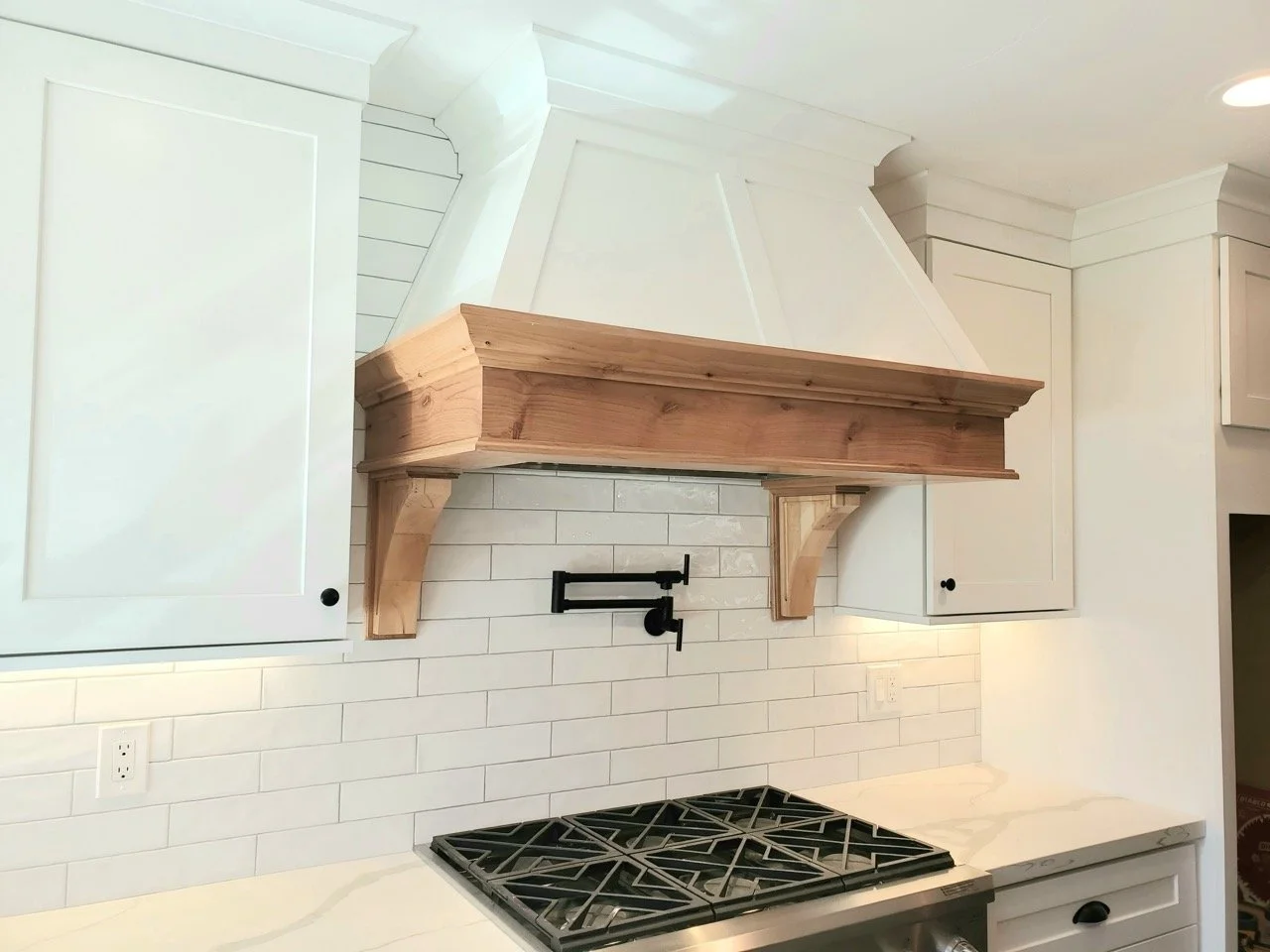 Whitekitchen_subwaytile_stovehoodwith_naturalwood.jpeg