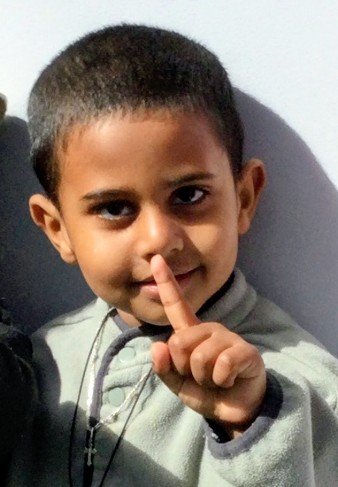 At St Mary's Children Centre, Kensington Victoria, a young boy holding his finger to his lips in a gesture of "number 1". Each child at St Mary's Children Centre, Kensington Victoria, is 1 of only 45 children, experiencing individualised learning.