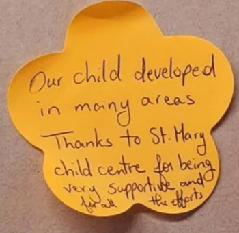 Parent feedback on a yellow sticky note with handwritten text that says, "Our child developed in many areas. Thanks to St. Mary child center for being very supportive and all the efforts."