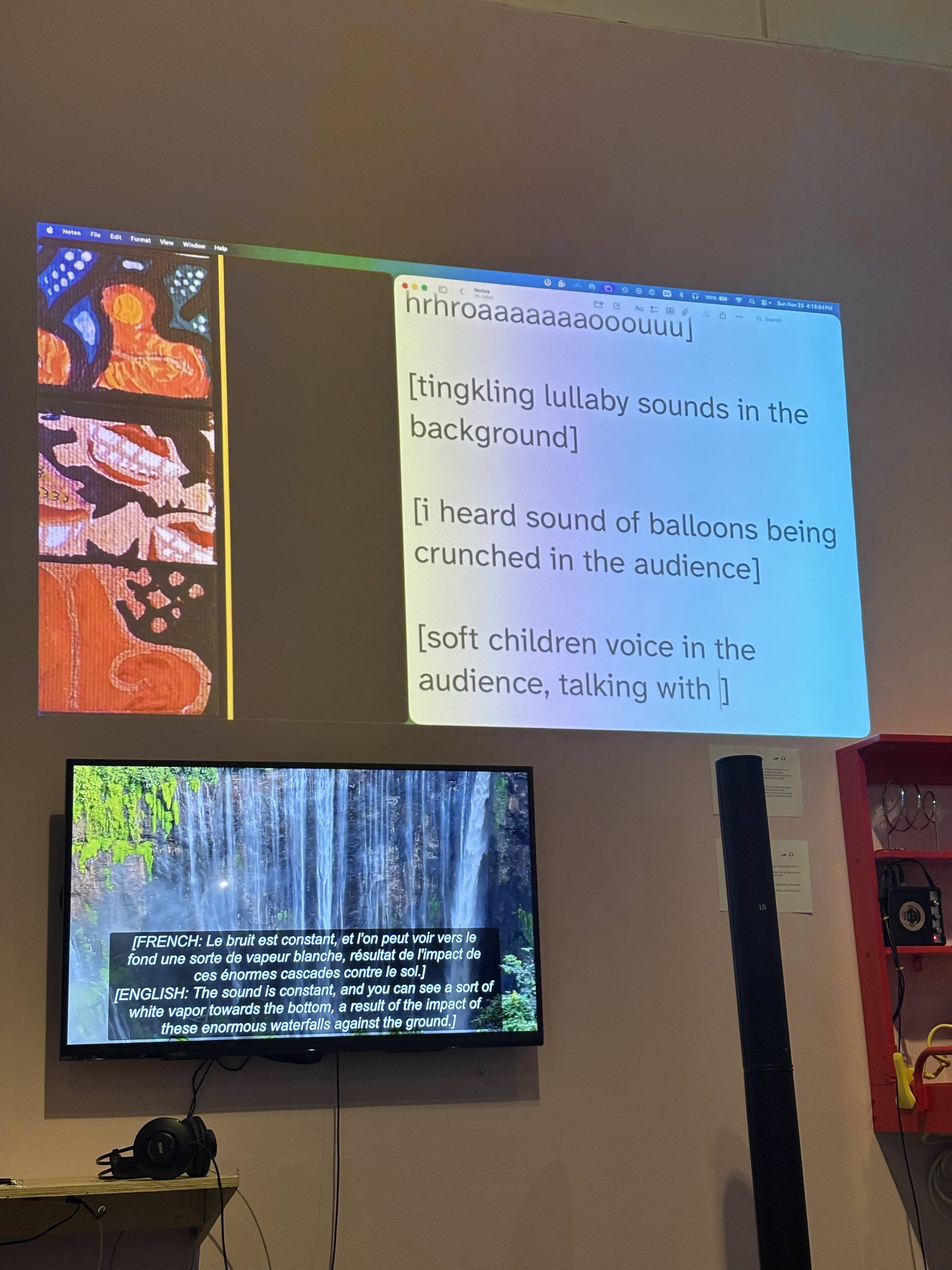Sound captions projected on a wall. They read, “[hrhroaaaaaaaooouuu] [tingkling lullaby sounds in the background] [i heard sound of balloons being crunched in the audience] [soft children voice in the audience, talking with ].” Photo: Frances Breden.