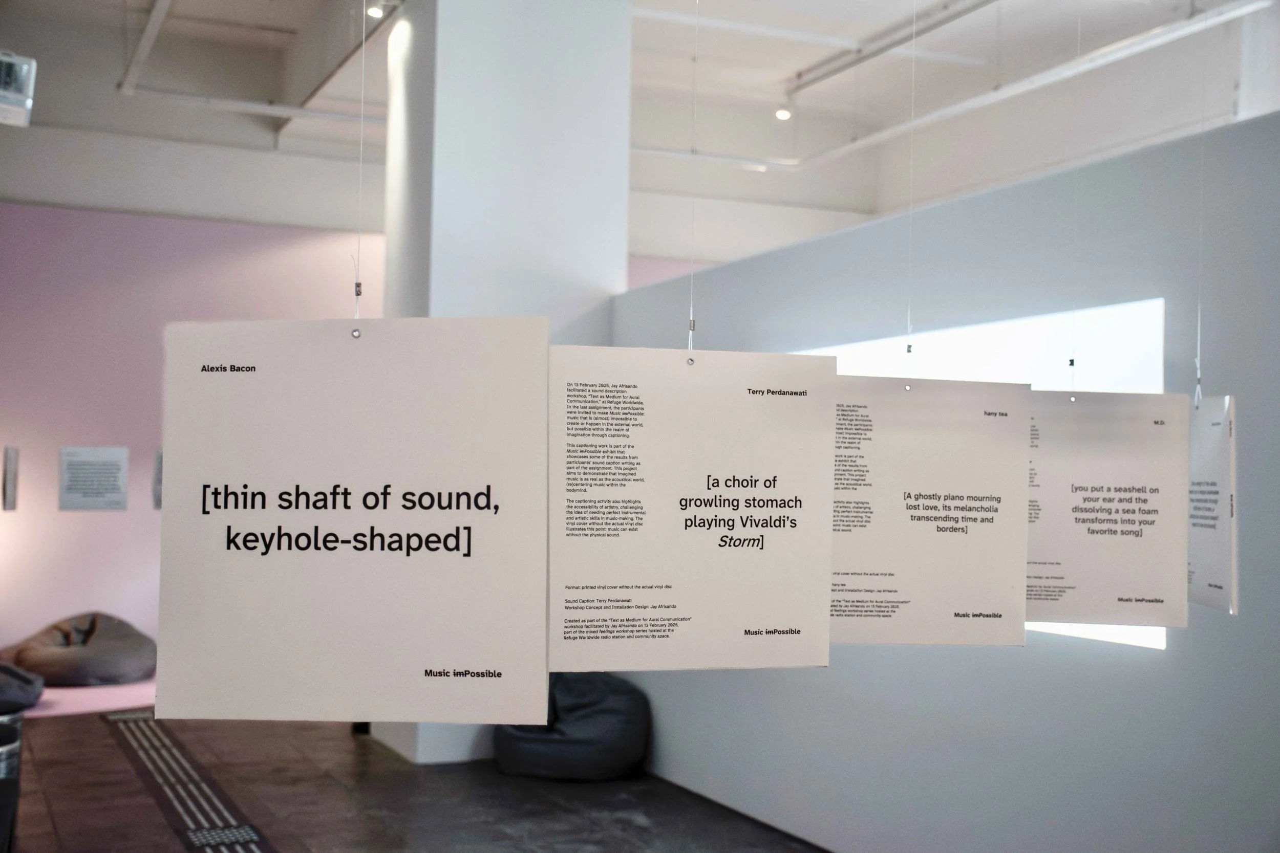 A series of five hung captioned vinyl covers with dark text on a white background.