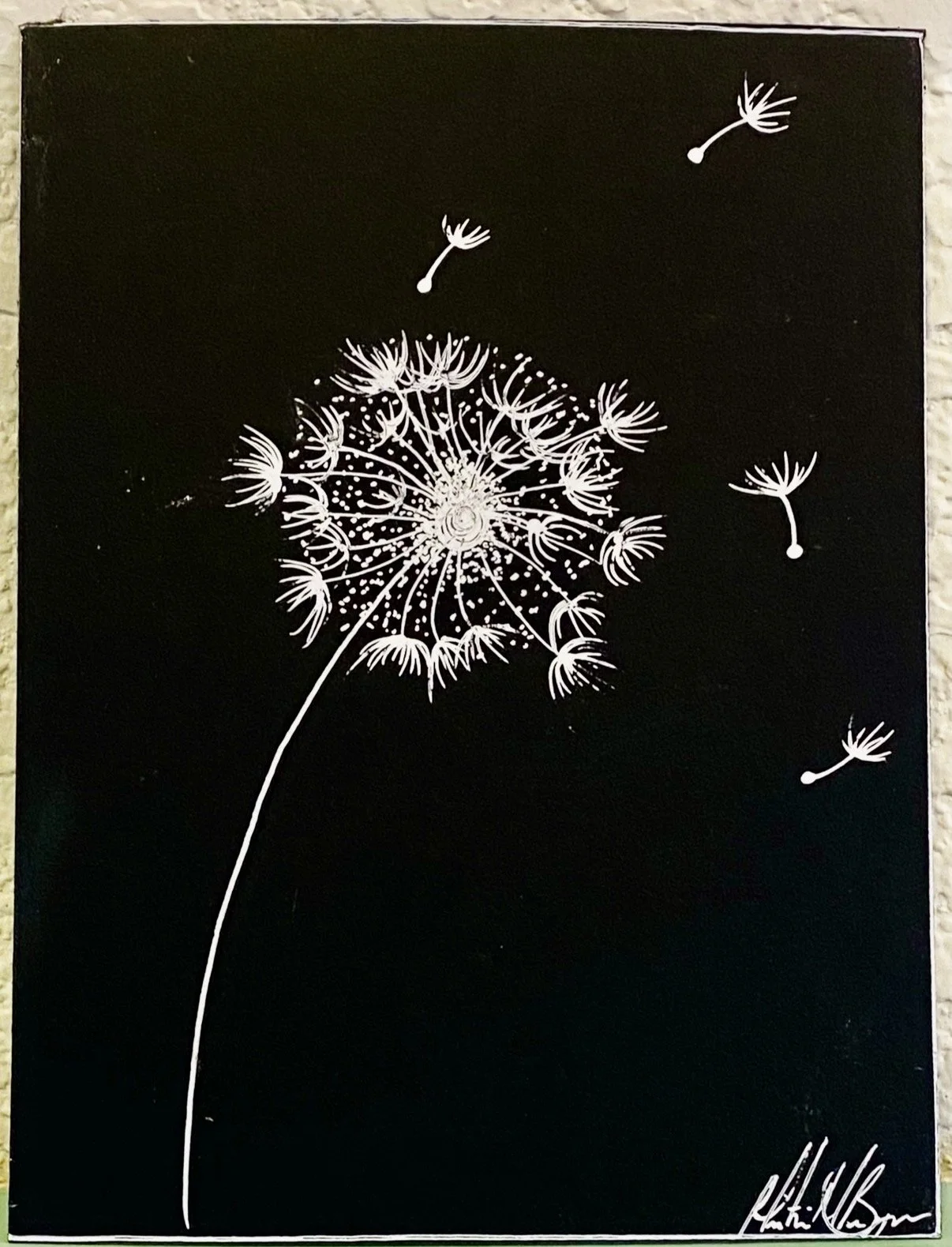 White dandelion with some seeds floating away on black background, with a signature in the bottom right corner.