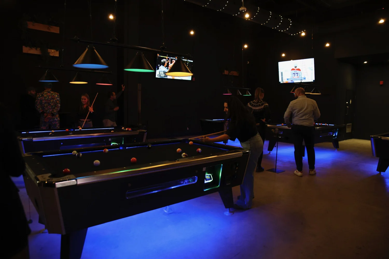 Joueurs autour des tables de billard chez FUNHUB