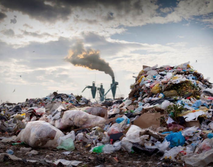a dump field with a factory behind polluting
