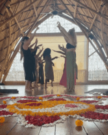 Groep mensen mediteert en danst tijdens een ESENSI retreat in een houten zaal