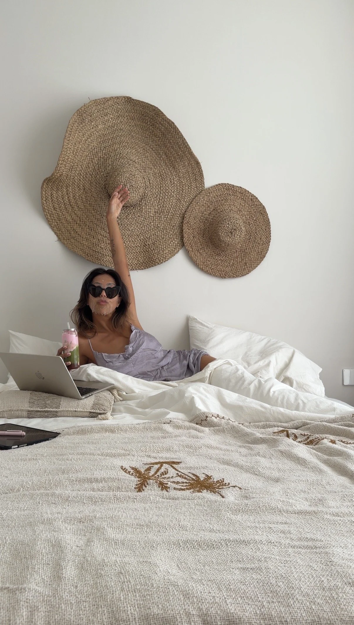 Vrouw ontspant op bed met laptop, drankje en zonnebril – lifestylebeeld ESENSI Lover Girl