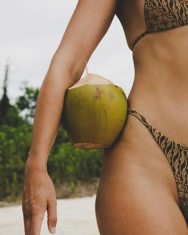 Vrouw in bikini met een kokosnoot op het strand, sfeerbeeld bij Lover Girl van ESENSI