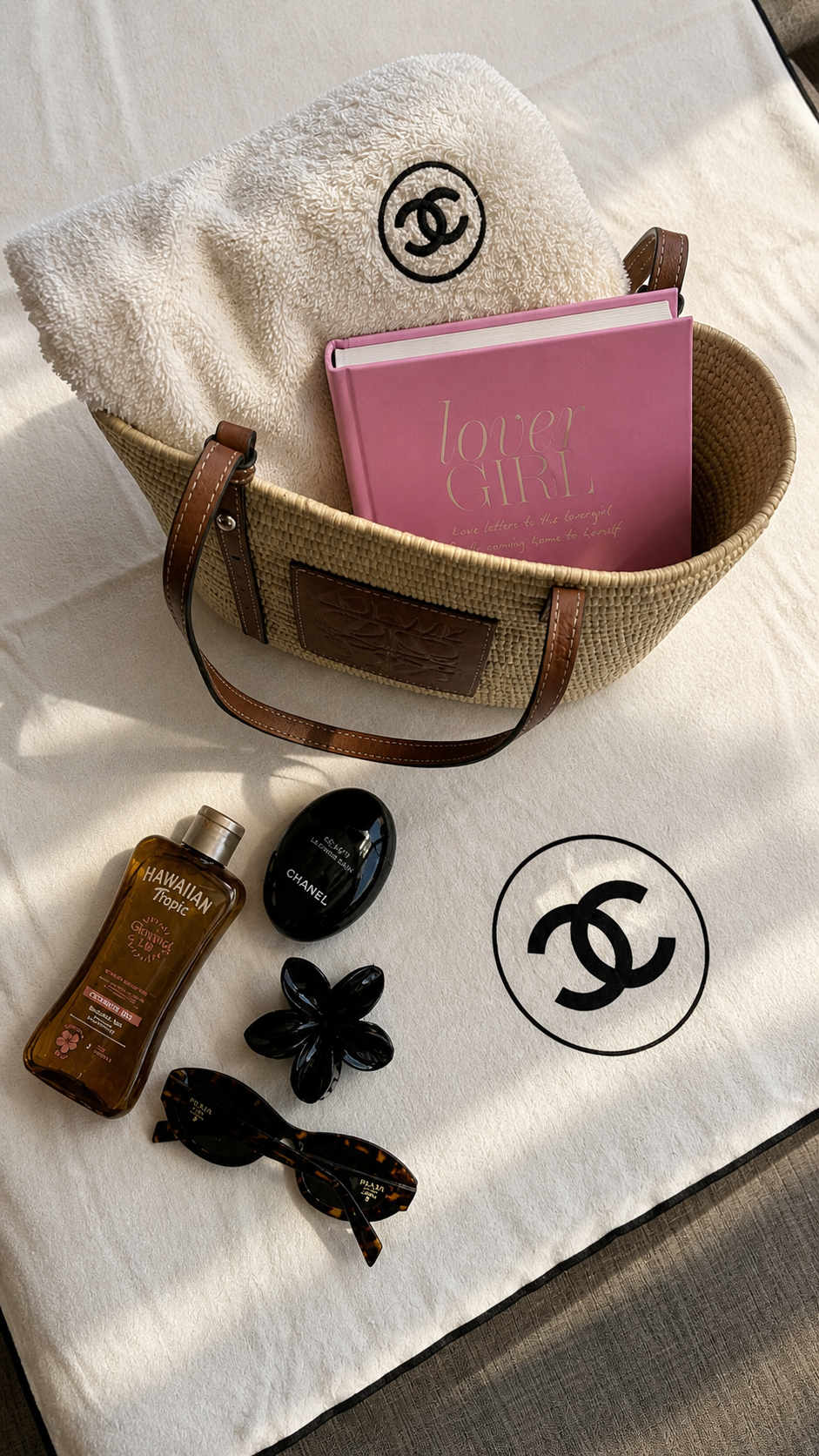 Strandtas flatlay met het boek Lover Girl, zonnebrandcrème en zomeraccessoires