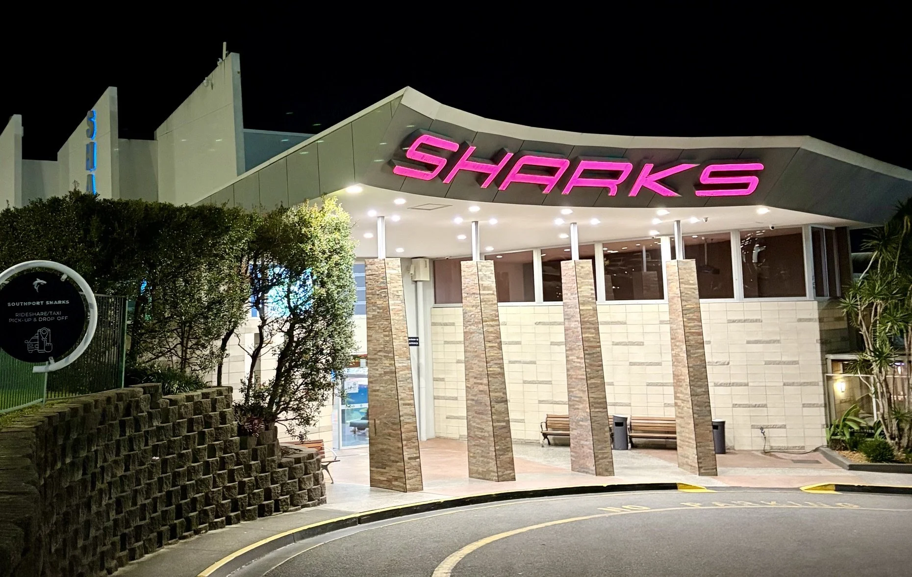 Night time picture of Southport Sharks exterior highlighting the large pink illuminated SHARKS signage.