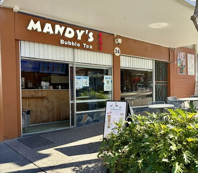 Exterior view of 'Mandy's Bubble Tea' in Southport showing outside tables and chairs and folliage on a sunny day.