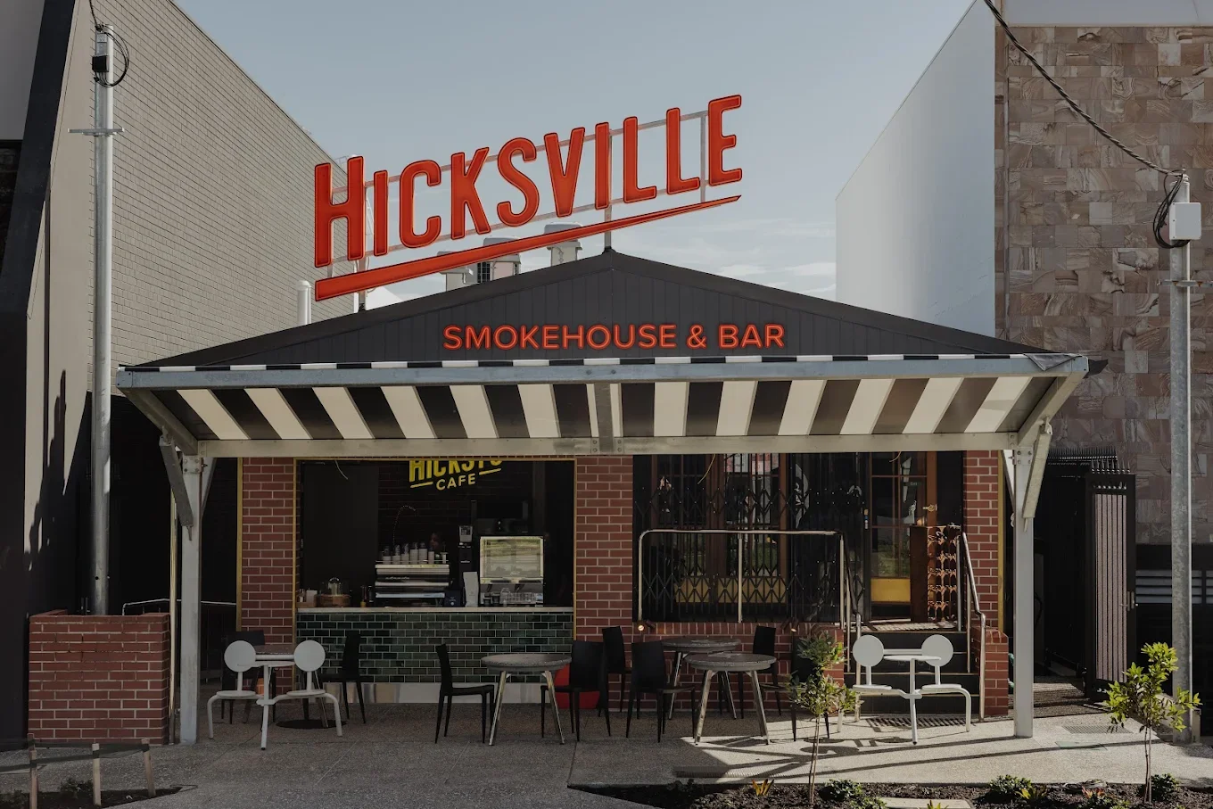 Exterior of Hicksville Smokehouse & Bar restaurant with outdoor seating.