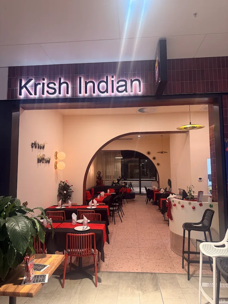 Entrance to Krish Indian restaurant with dining tables decorated for the holidays.