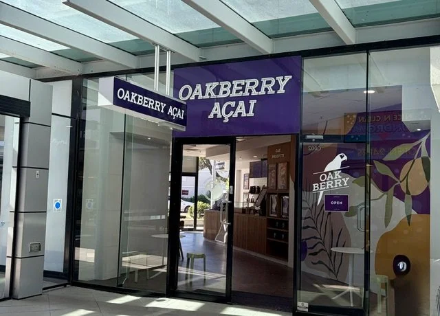 Entry to 'OAKBERRY ACAI' AT Southport Central with large white signage on a purple background.