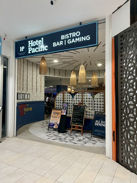 Entry to 'Hotel Pacific" in Australia Fair showing signage above doorway and gold lighting within.