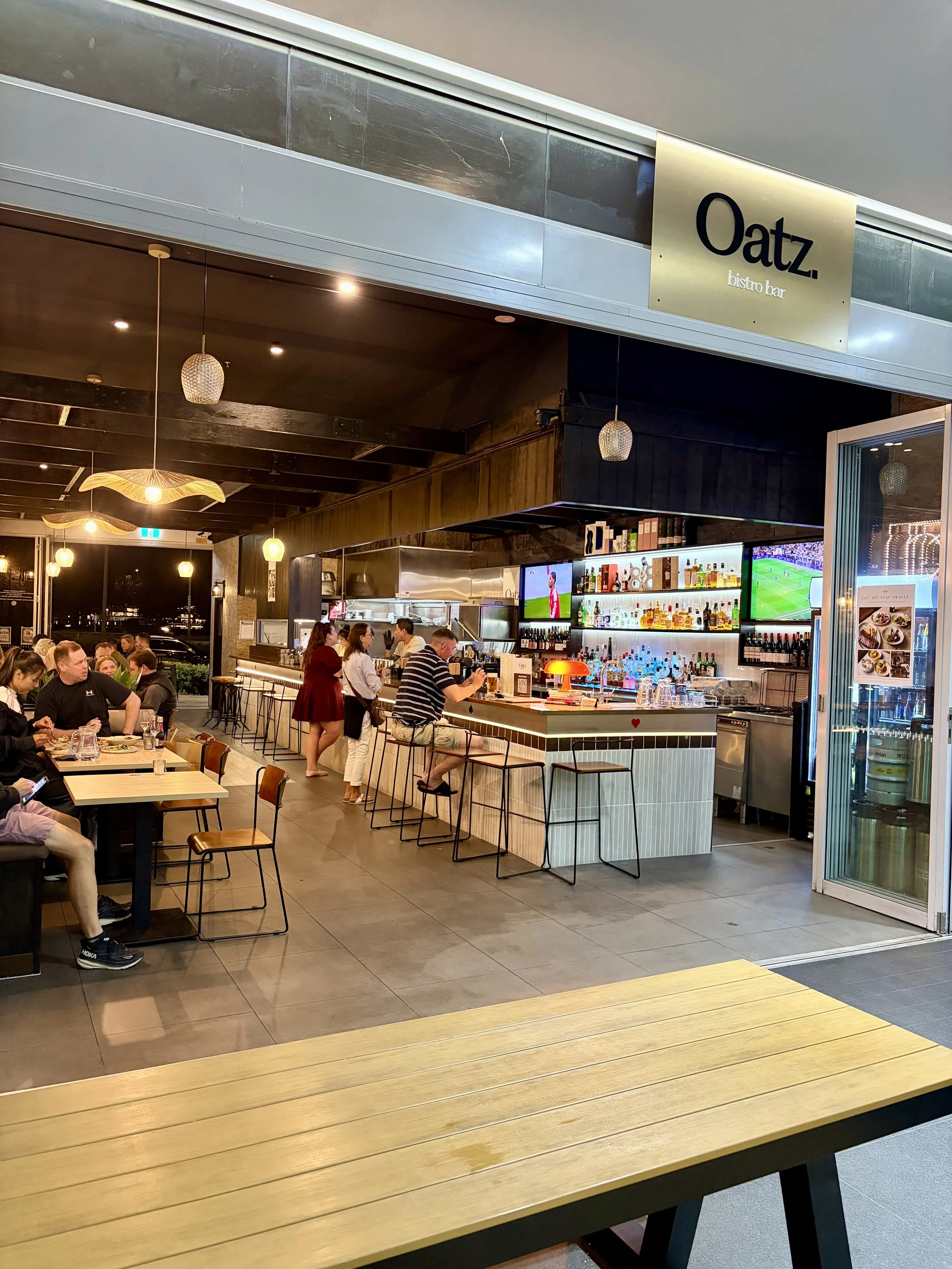 Front view of new Asian fusion restaurant 'Oatz.' in Southport showing busy bar with people also seated at tables.