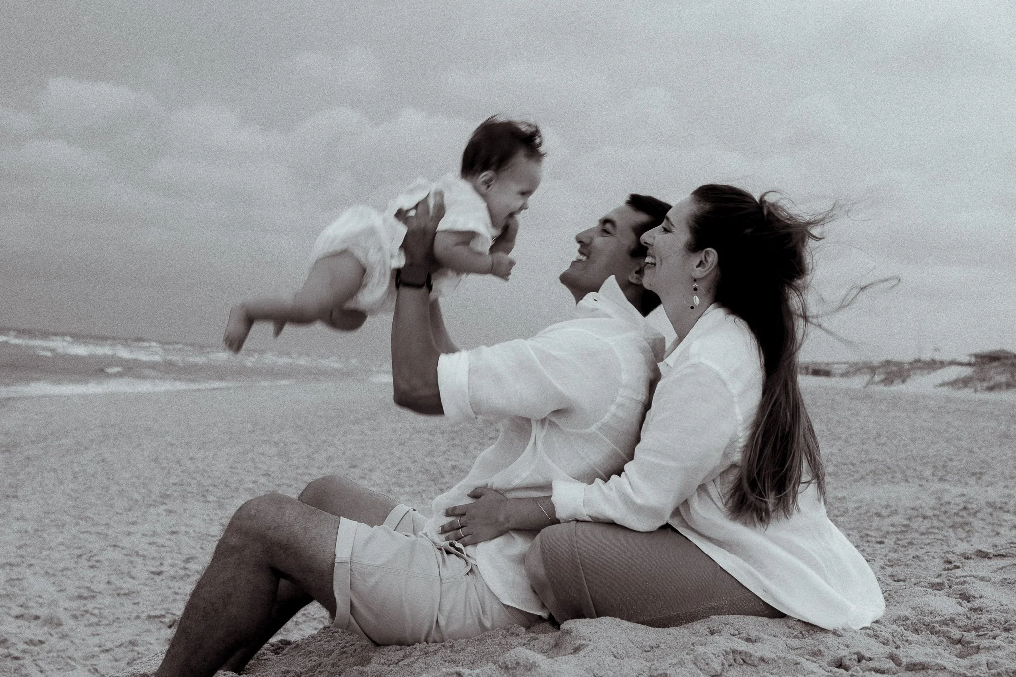 seance-photo-famille-hossegor-parents-bebe-jeu-sable-noir-et-blanc.jpg
