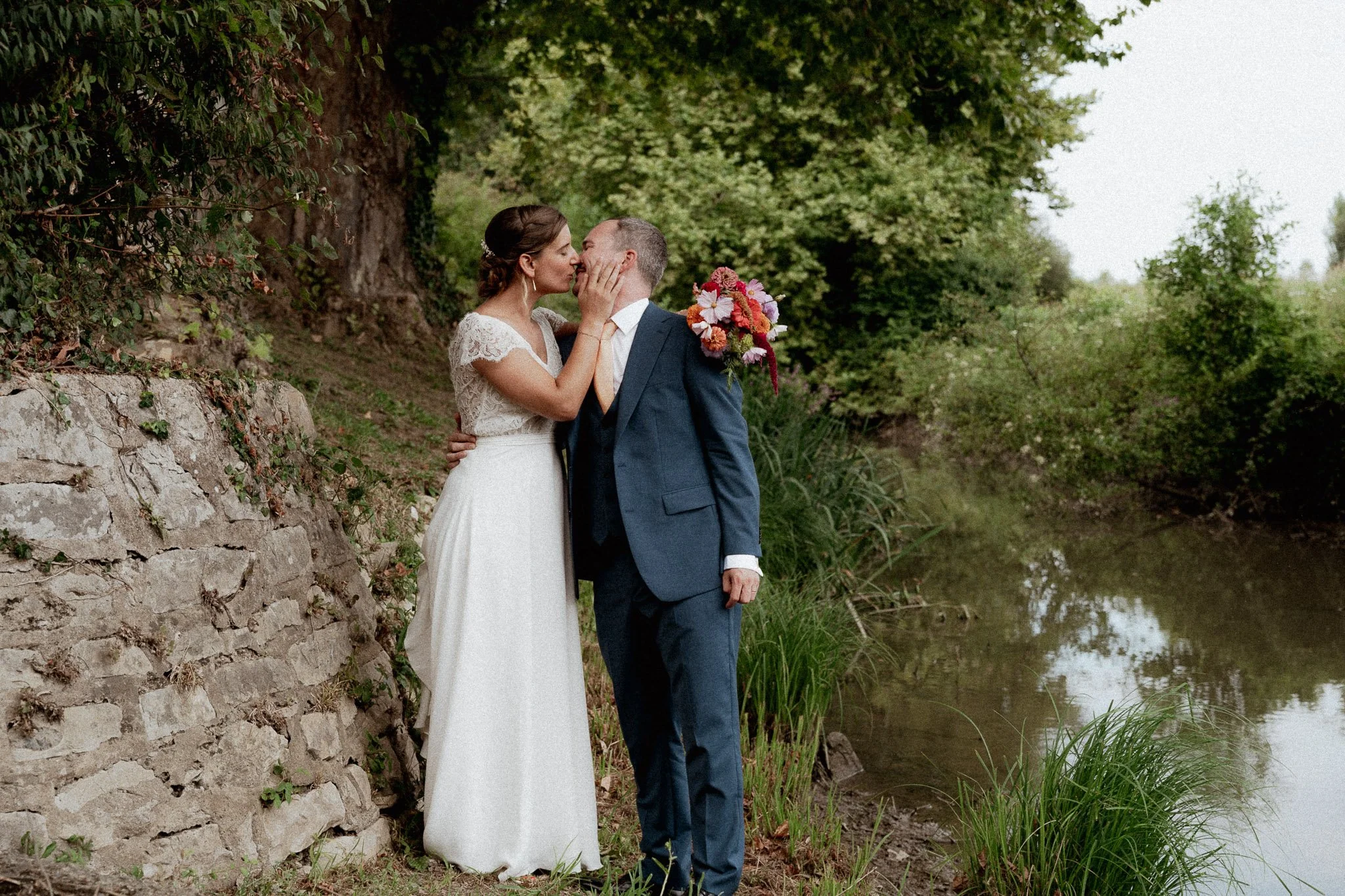photographe-mariage-capbreton-baiser-maries-bord-eau-bouquet.jpg