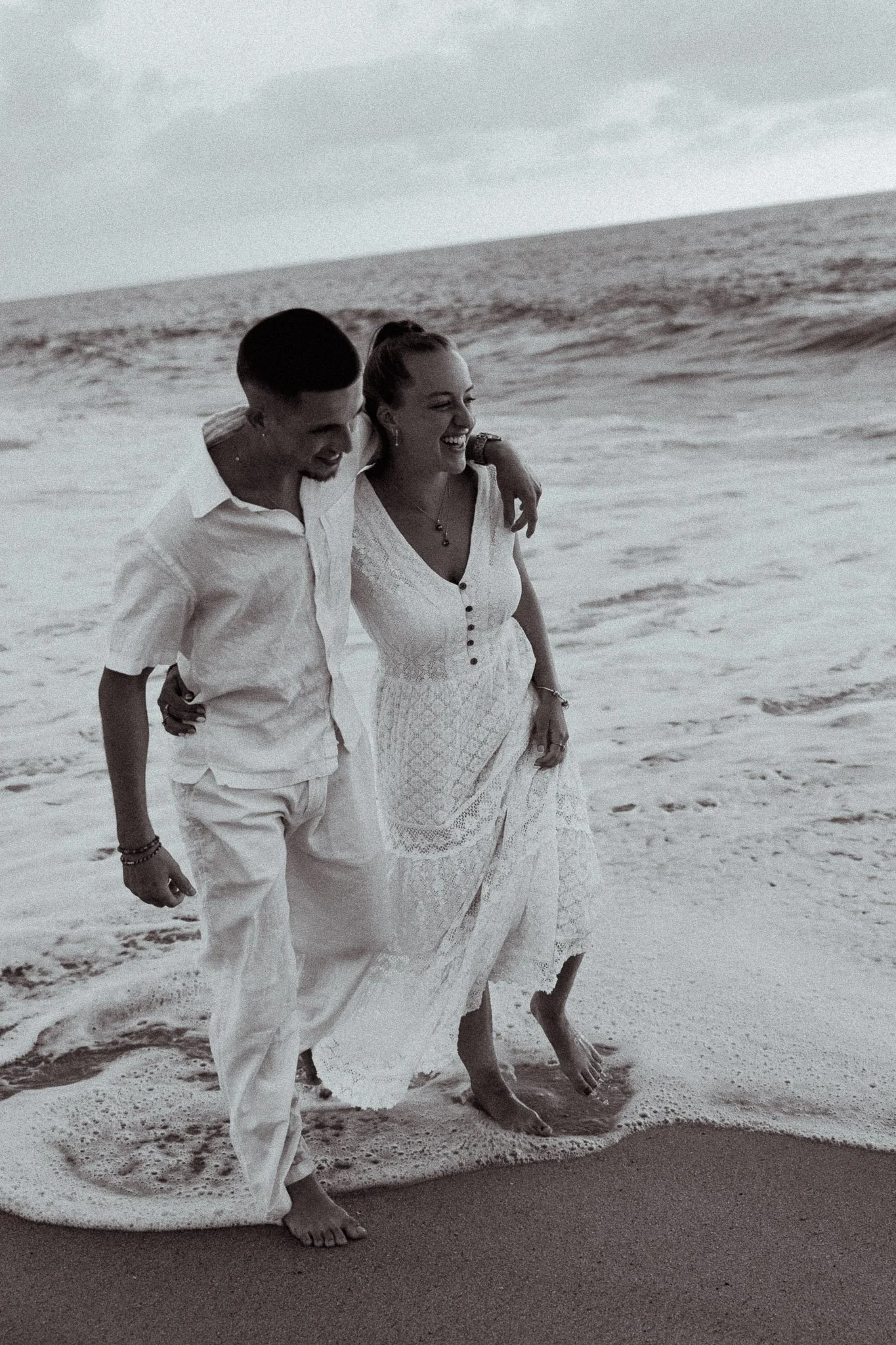 photographe-couple-capbreton-couple-pieds-dans-vagues-noir-et-blanc.jpg