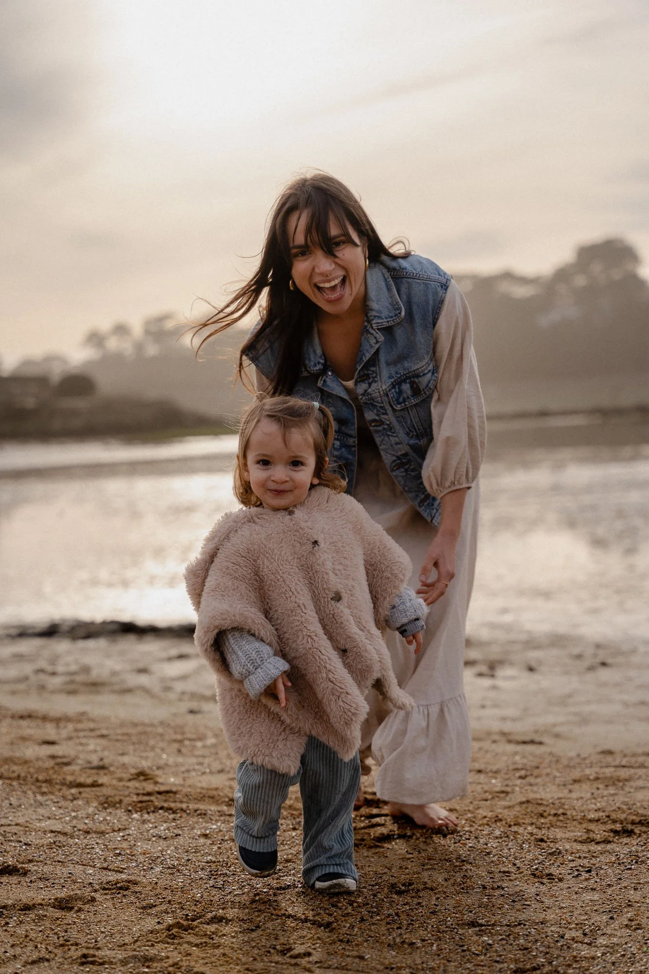 Photo d'enfant jouant sur la plage au coucher de soleil