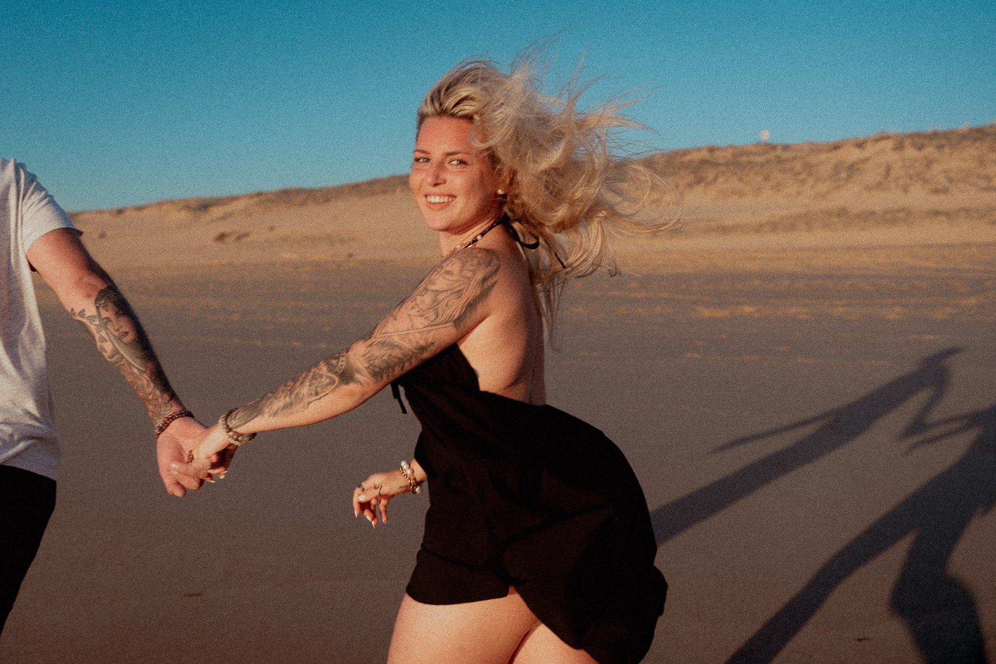 photographe-couple-messanges-jeune-femme-main-tendue-dune.jpg