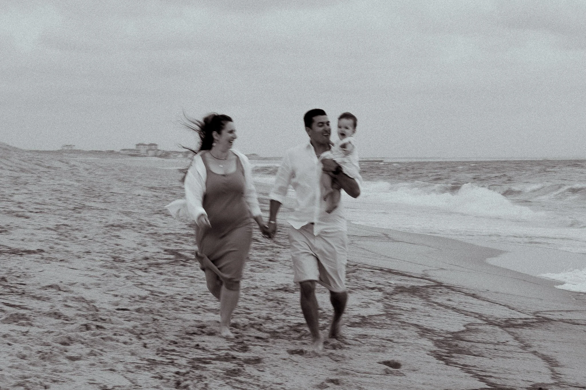 seance-photo-famille-hossegor-parents-bebe-course-noir-et-blanc.jpg