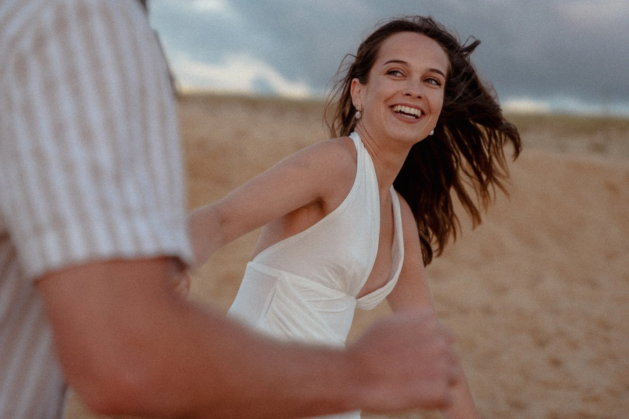 photographe-couple-capbreton-jeune-femme-sourire-cheveux-au-vent.jpg