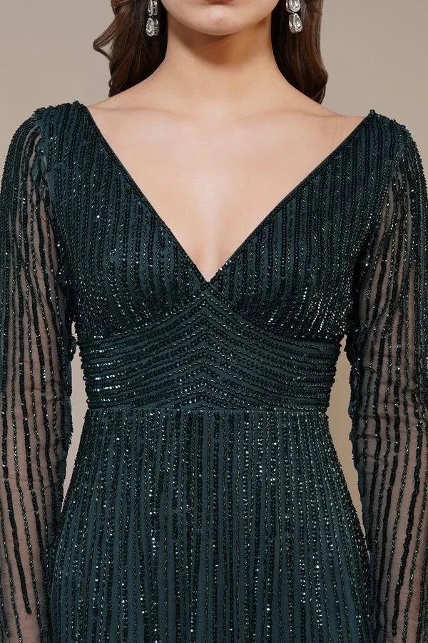 Close-up of a woman wearing a black, long-sleeved, V-neck beaded evening gown with vertical stripe patterns and earrings.