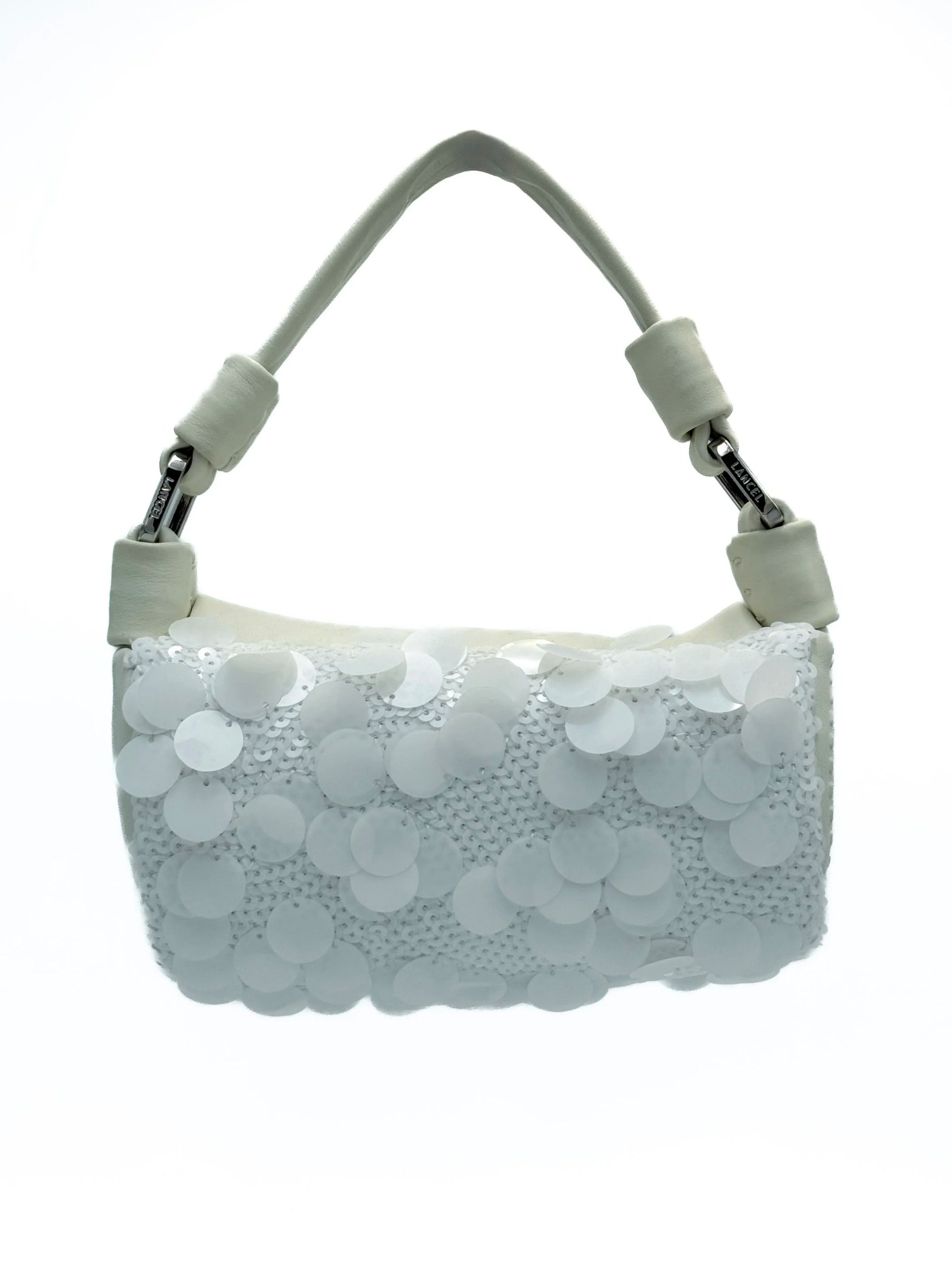 A white handbag decorated with sequins and a fabric strap handle
