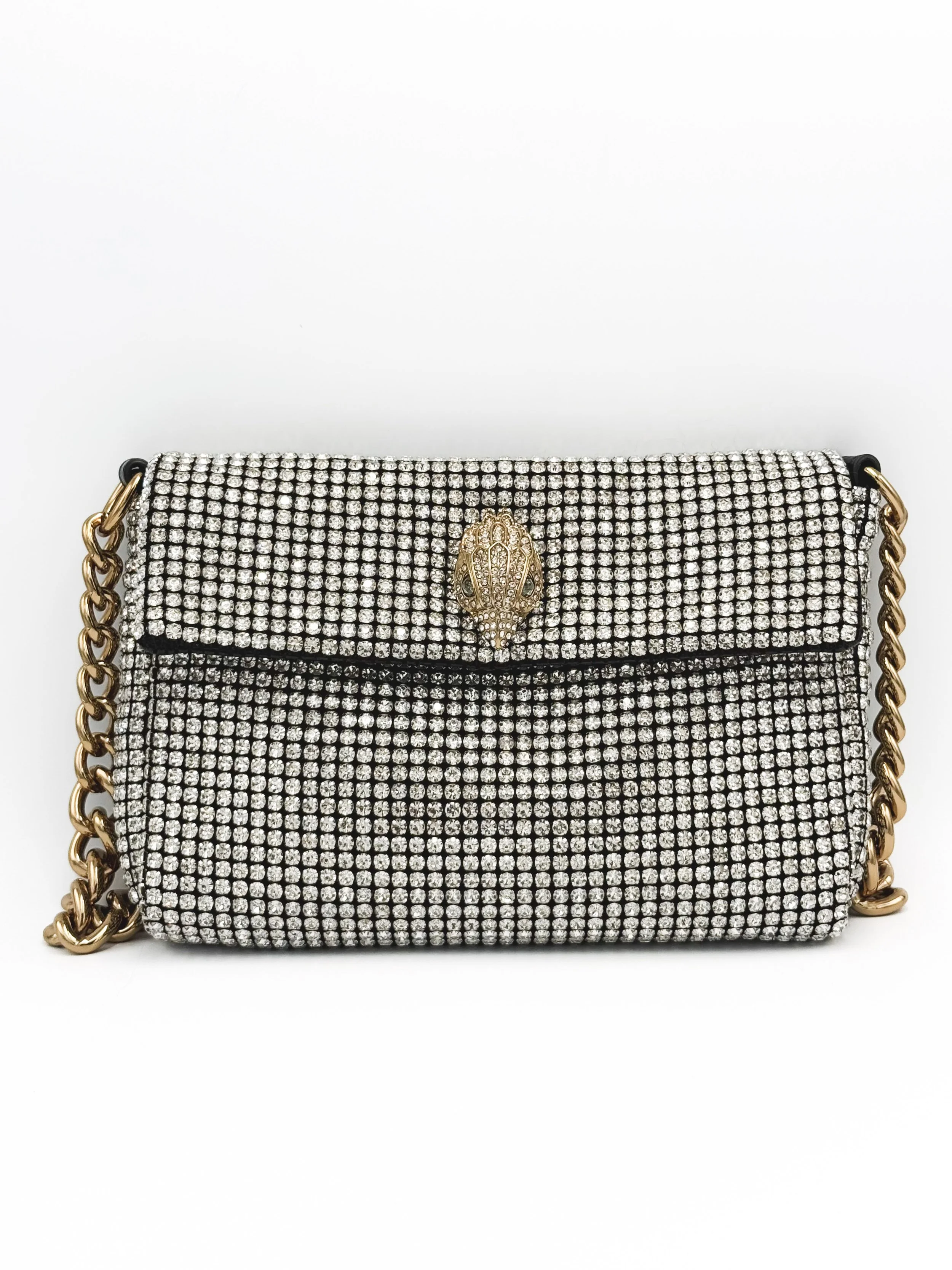 A black handbag covered in numerous small rhinestones, with a gold chain strap and a decorative gold emblem on the front.