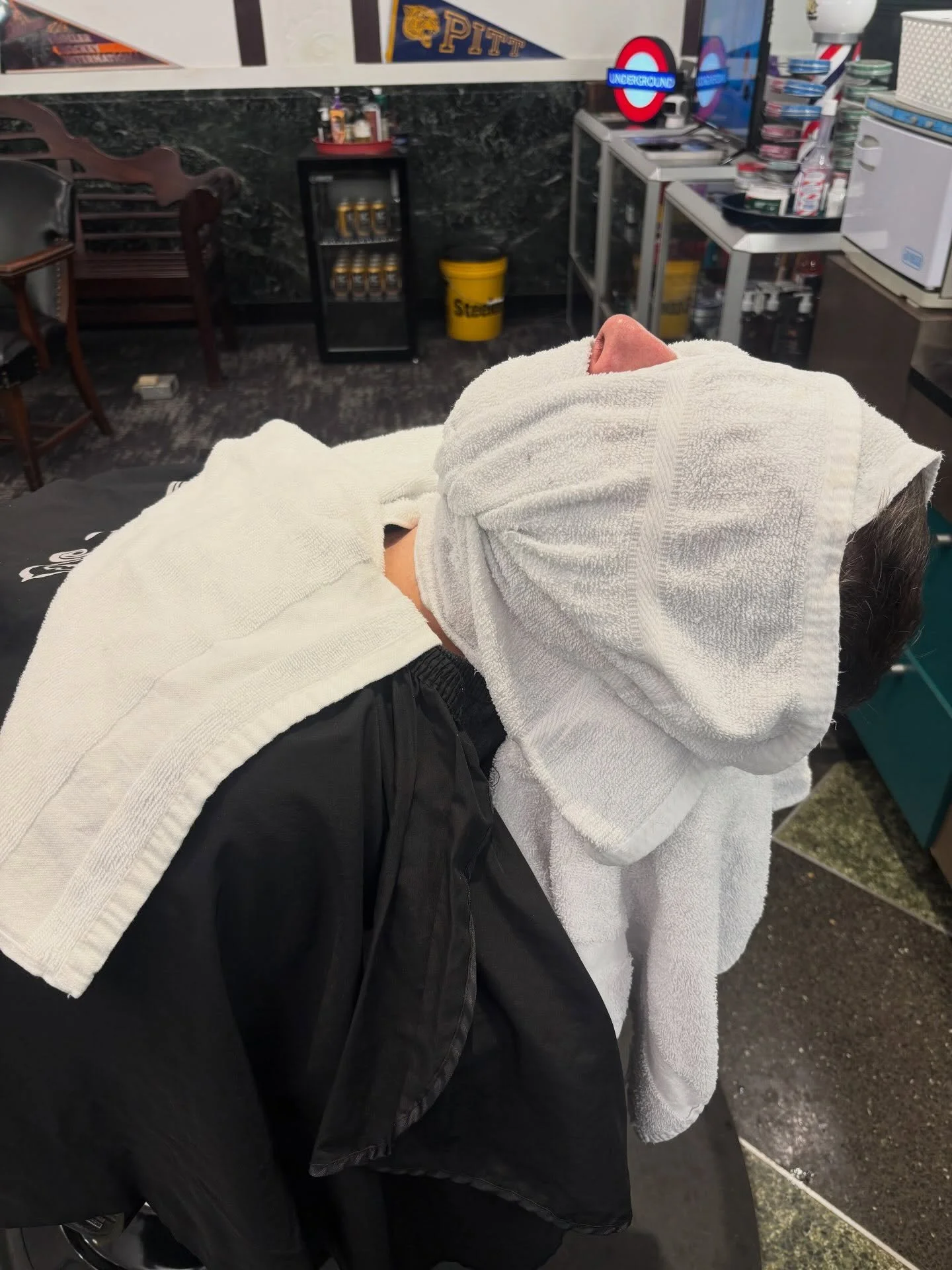 Hot towel preparation for a straight razor shave at Golden Triangle Barber Shop