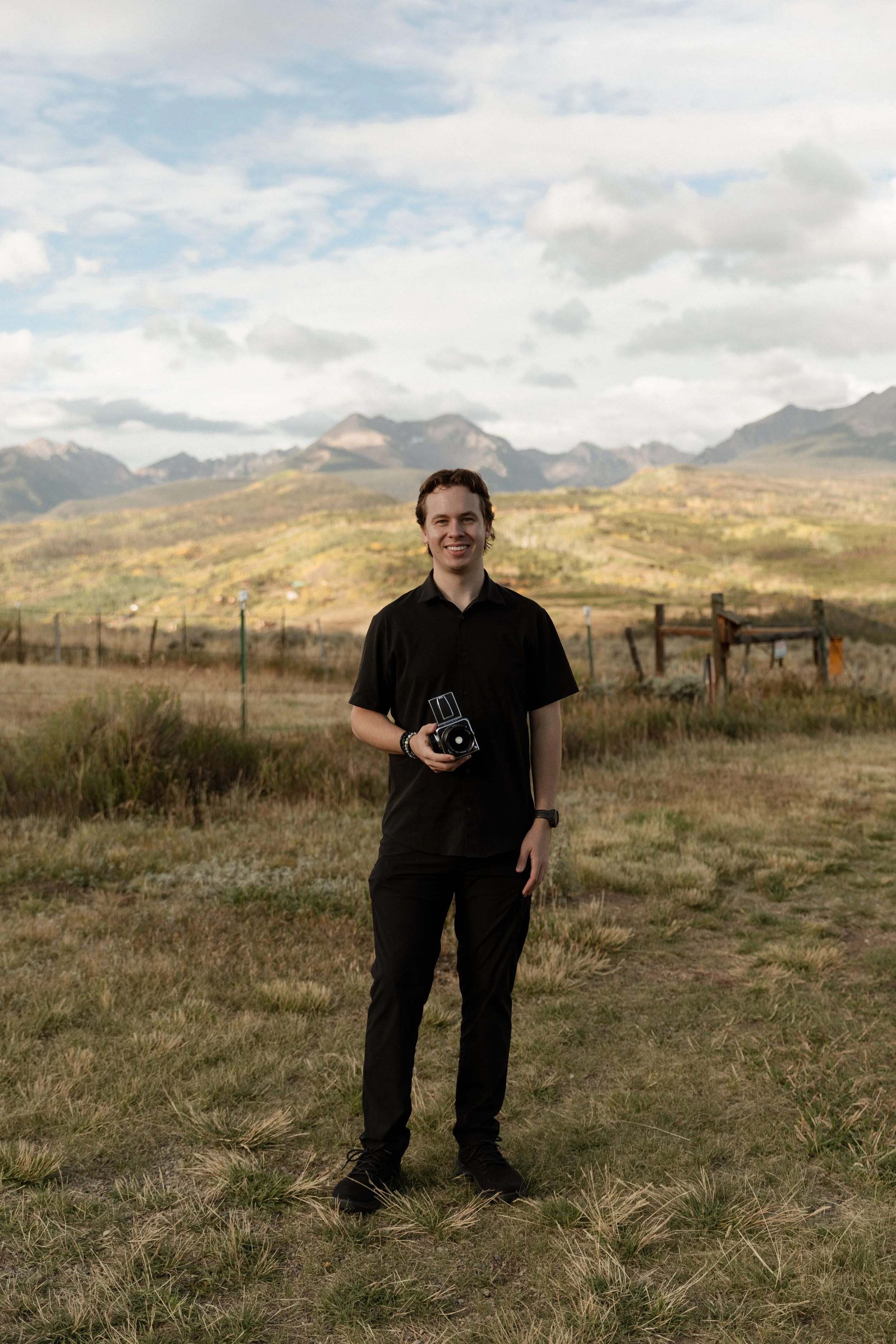 Joey Trcka intimate wedding photographer holding film camera in the mountains of Colorado.