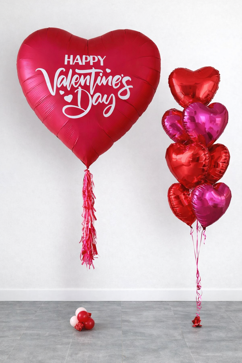 Heart-shaped balloons for Valentine's Day, with a large red balloon message 'Happy Valentine's Day' and smaller red and pink balloons on the right.